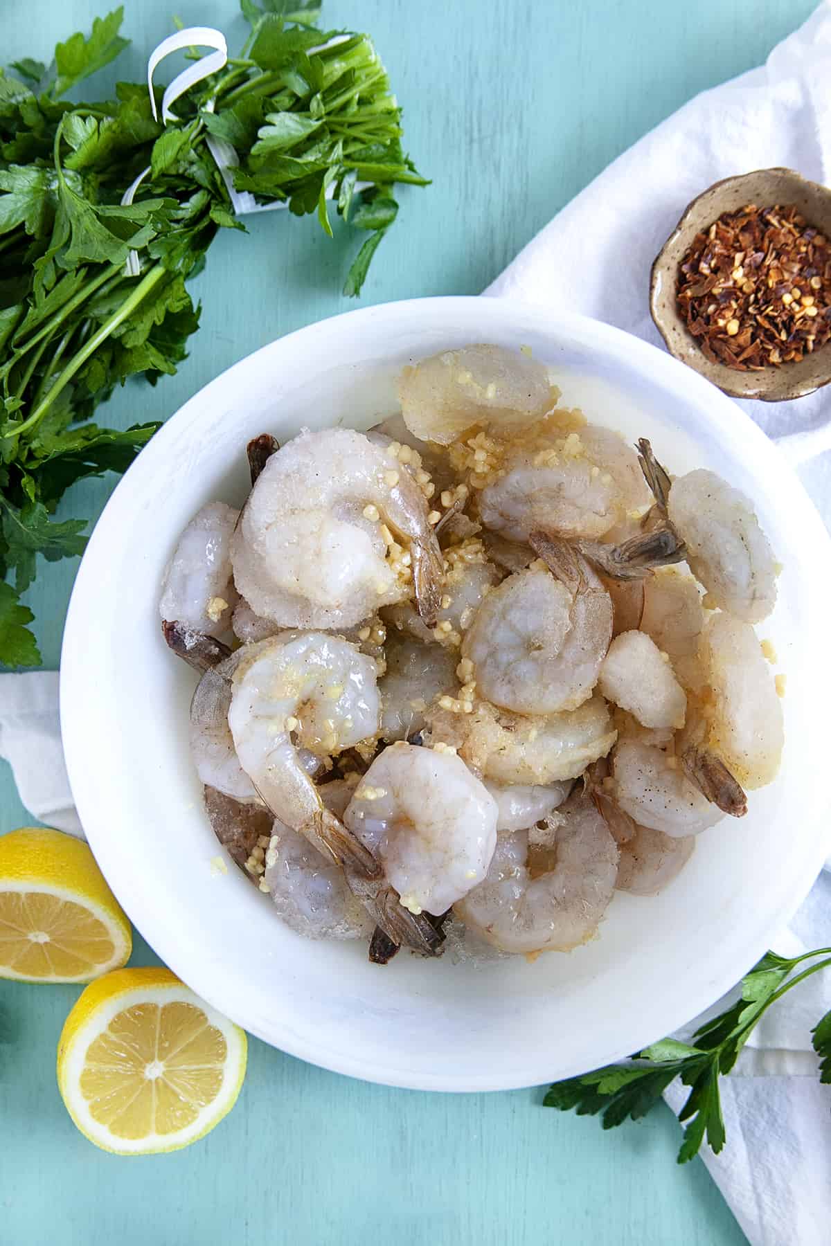 Raw shrimp in a bowl with garlic. 
