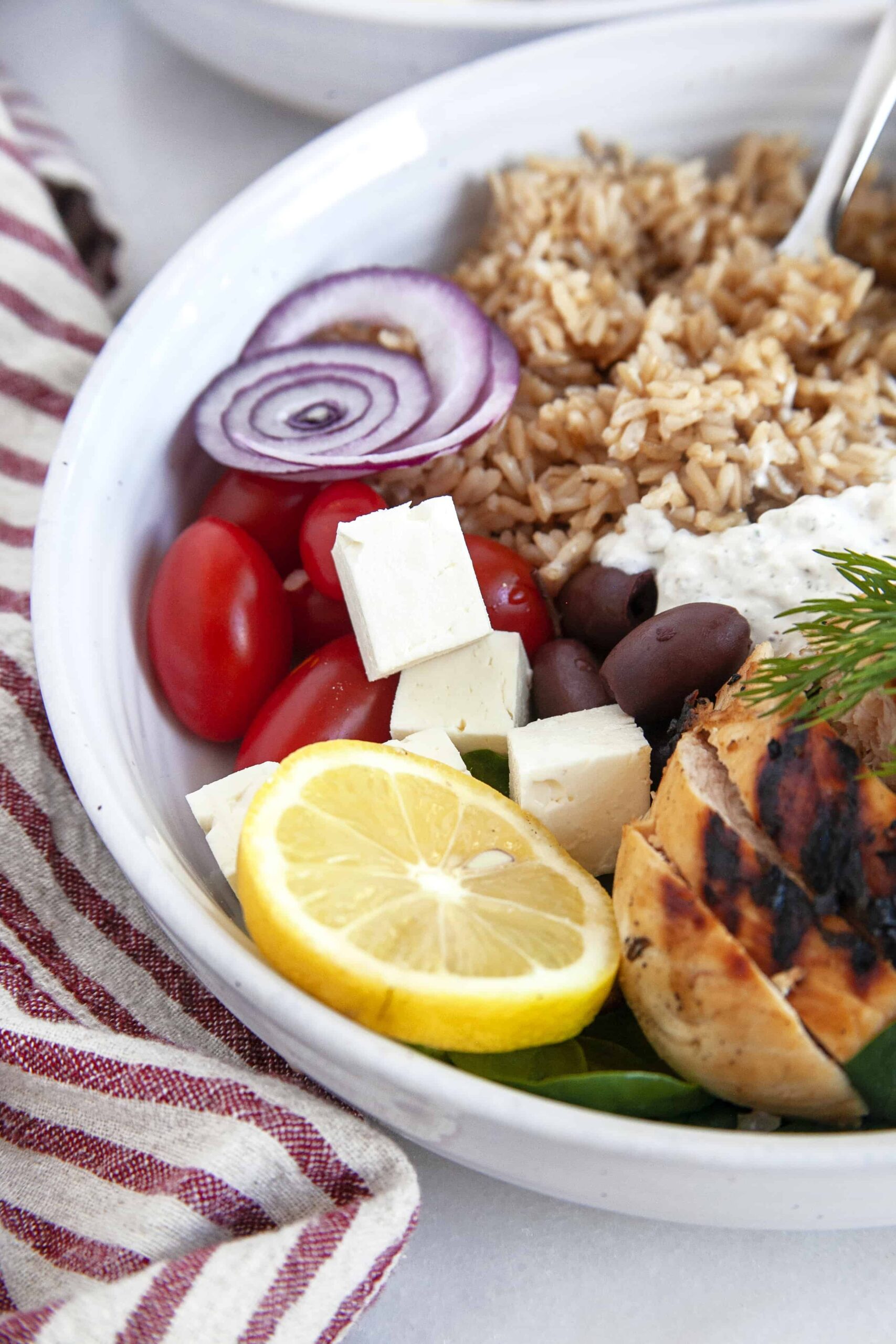 Showing half a bowl of Greek Chicken Bowl. 