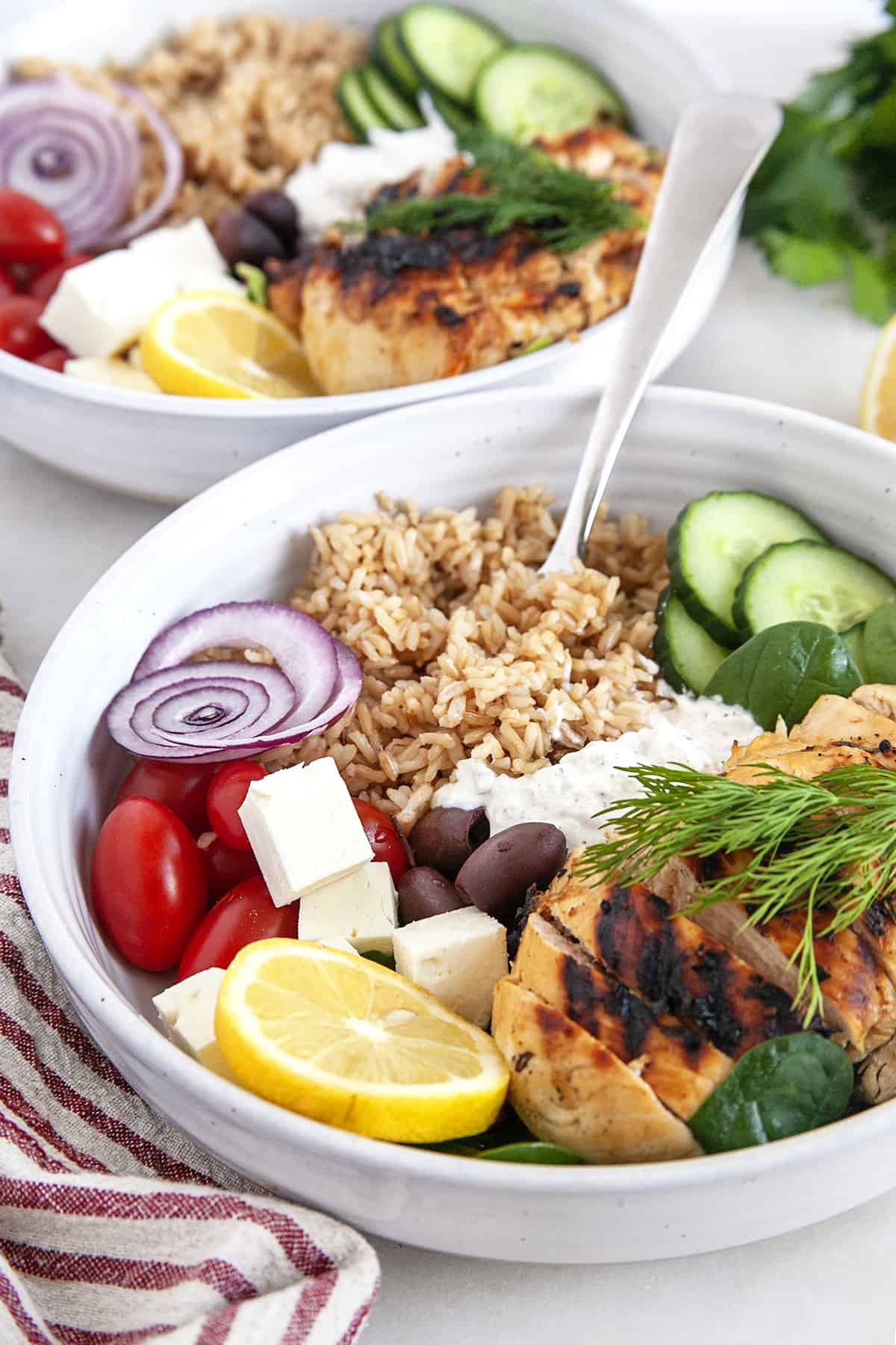 Fork diving into the rice in a Greek Chicken Bowl. 