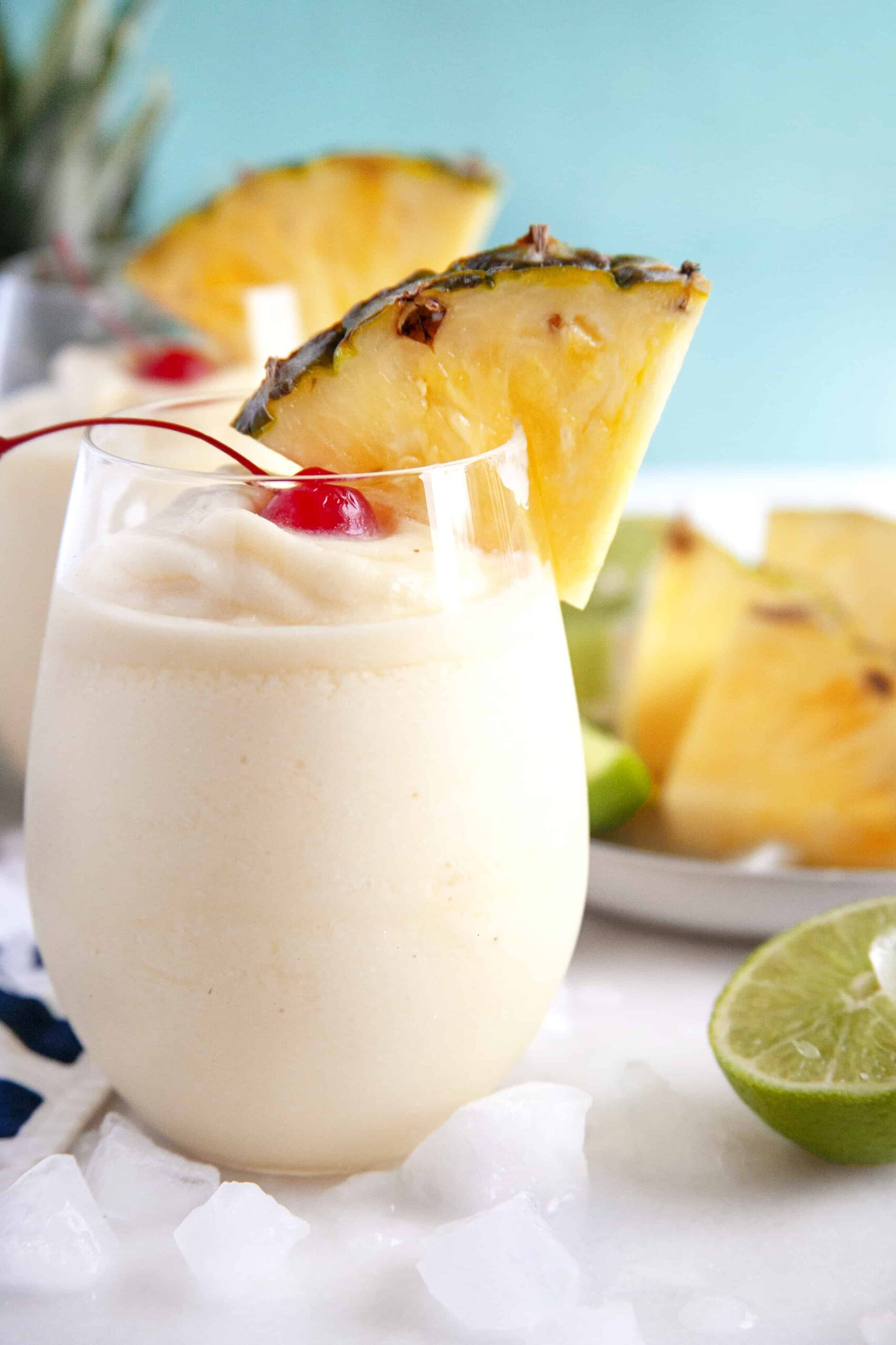 Close-up shot of two glasses in a row, one behind the other of virgin pina coladas. 