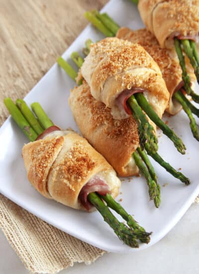 Platter of ham and cheese crescent rolls with asparagus.