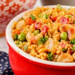 Square photo of couscous in a red bowl.