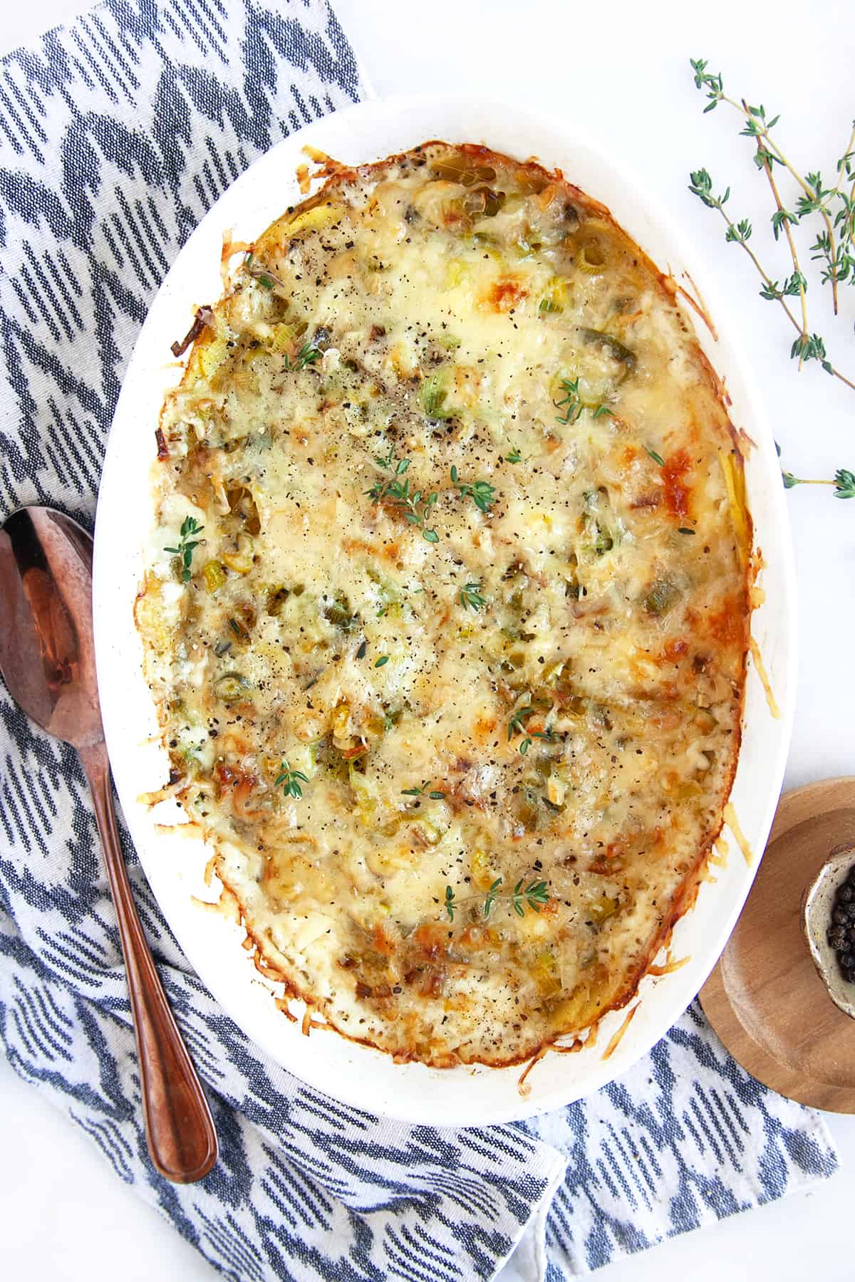 Overhead shot of Potato Leek Gratin in an oval white casserole. 