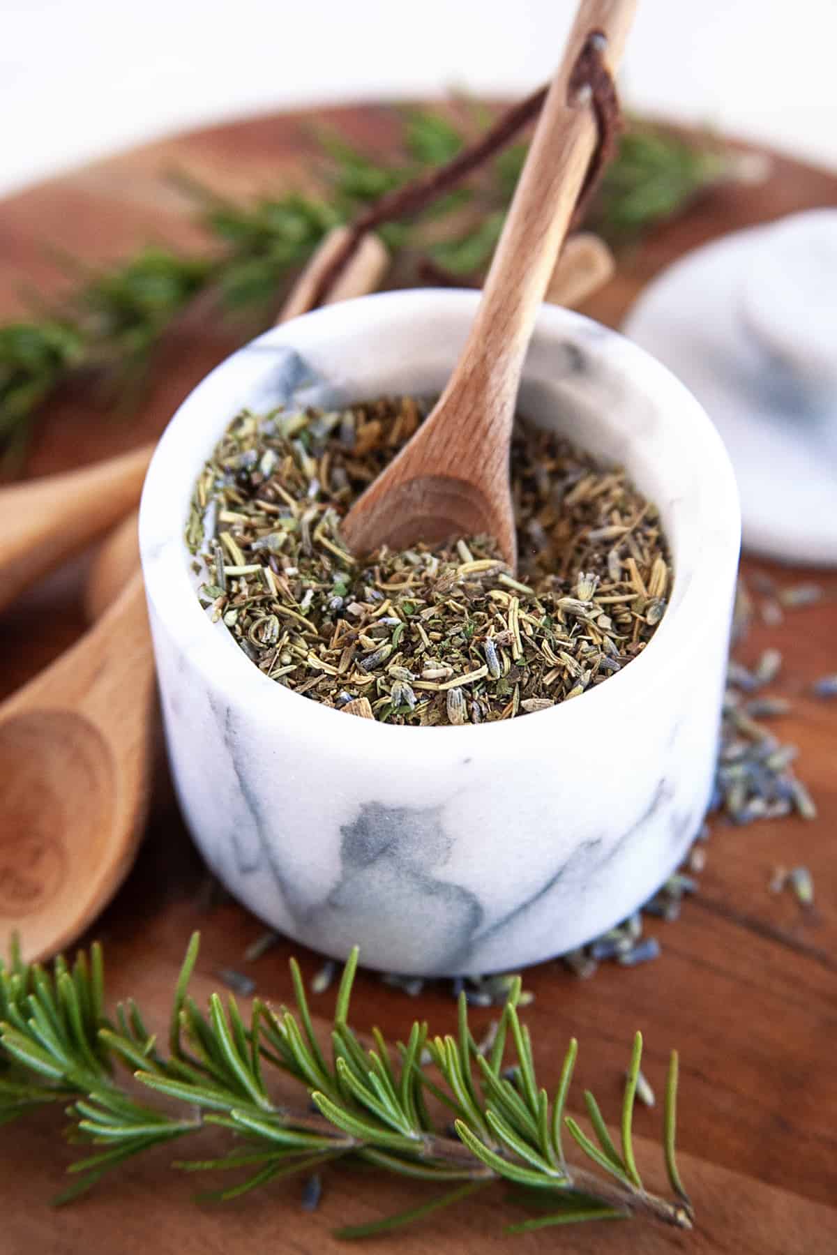 Herbs de Provence in a mortar and pestle with a wooden spoon. 