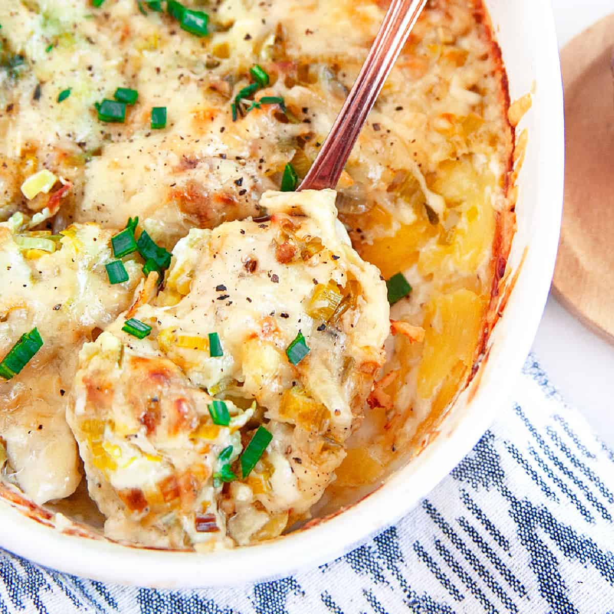 Square photo of scooping out au gratin potatoes. 