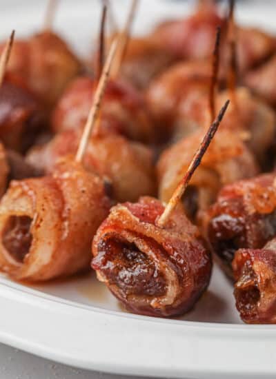 Bacon-Wrapped Dates on a white plate.