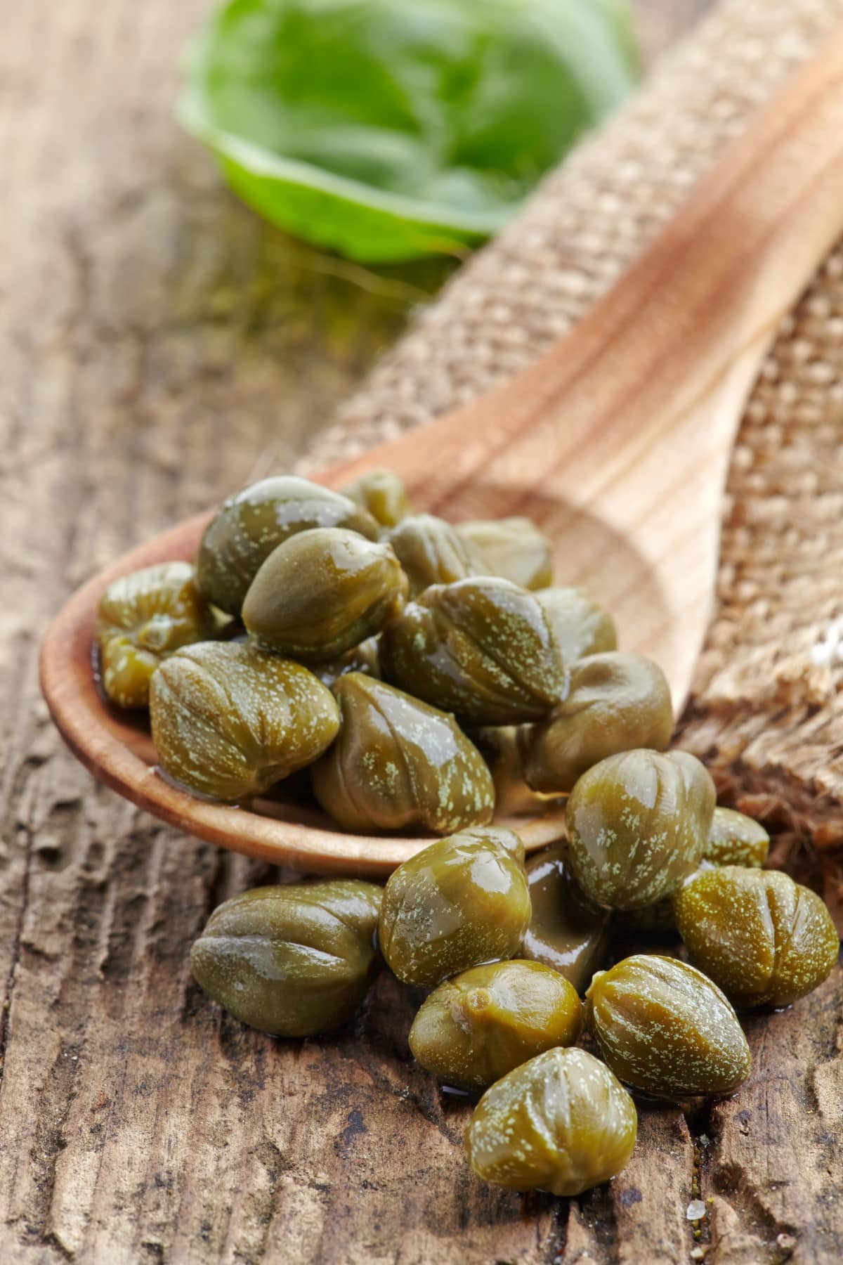 Capers macro in a wooden spoon.