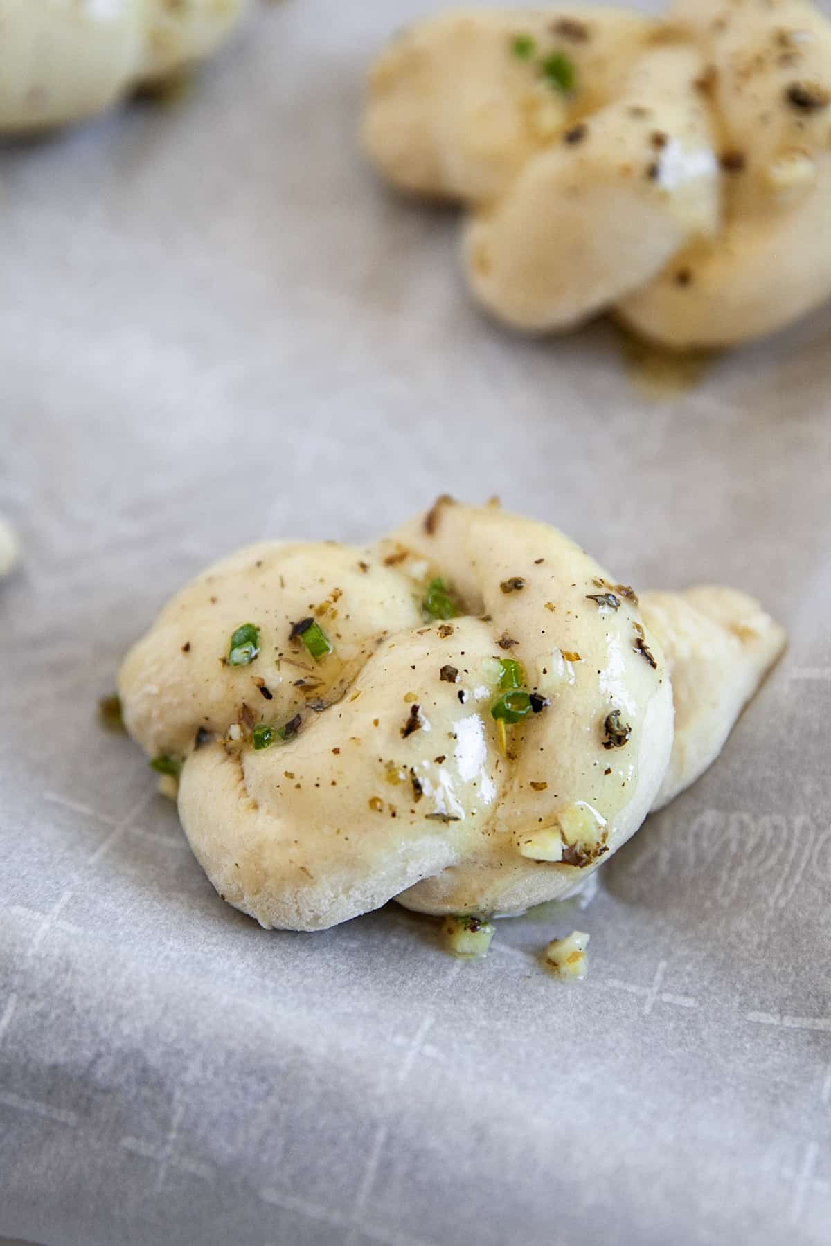 Garlic knots with butter on them ready for the oven. Close-up of one. 