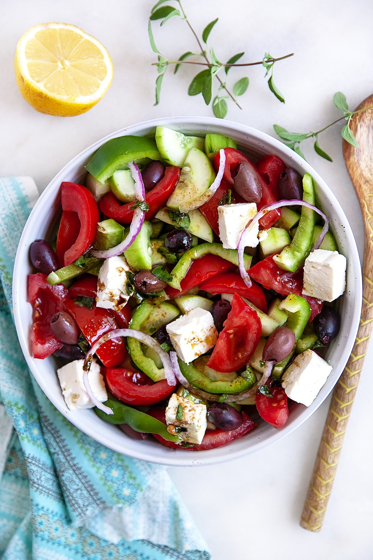 Overhead shot of Greek Salad in a bowl with a wooden spoon. 