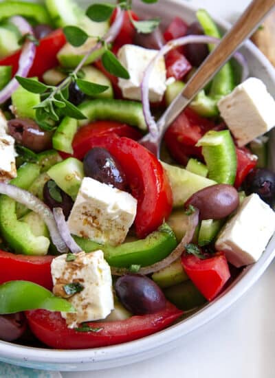 A spoon in a bowl of Greek Salad.