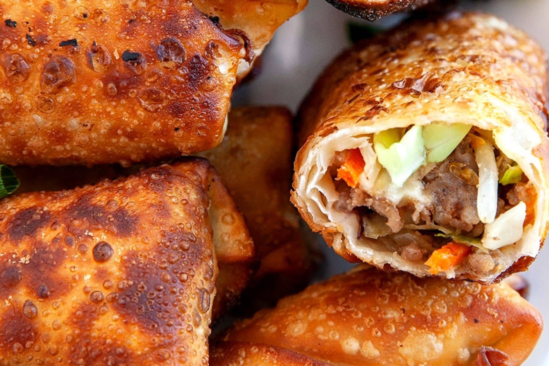 These Crispy Homemade Egg Rolls are an amazing make-ahead appetizer or side dish. They bring back lots of wonderful memories of my childhood. Close up of egg rolls.