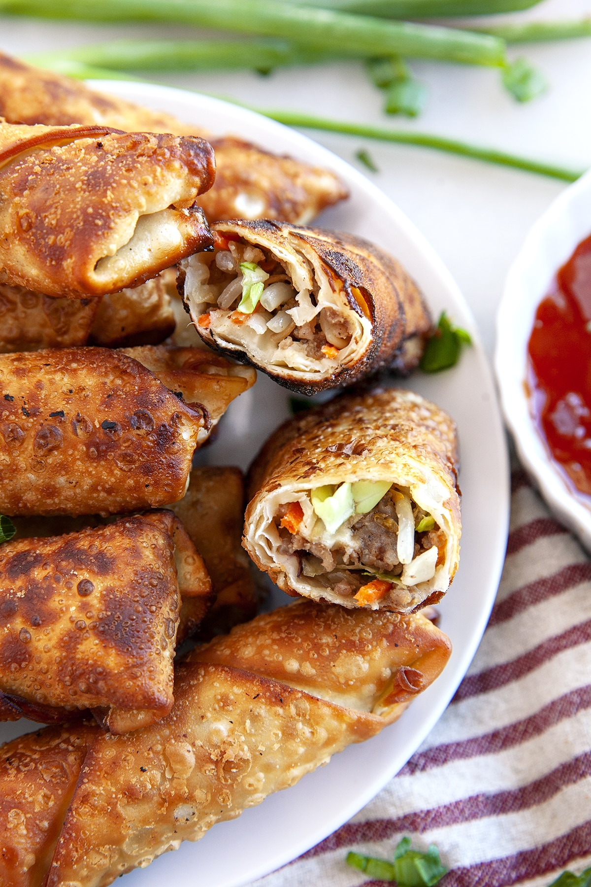 Close-up of crispy fried egg rolls with one cut in half. 