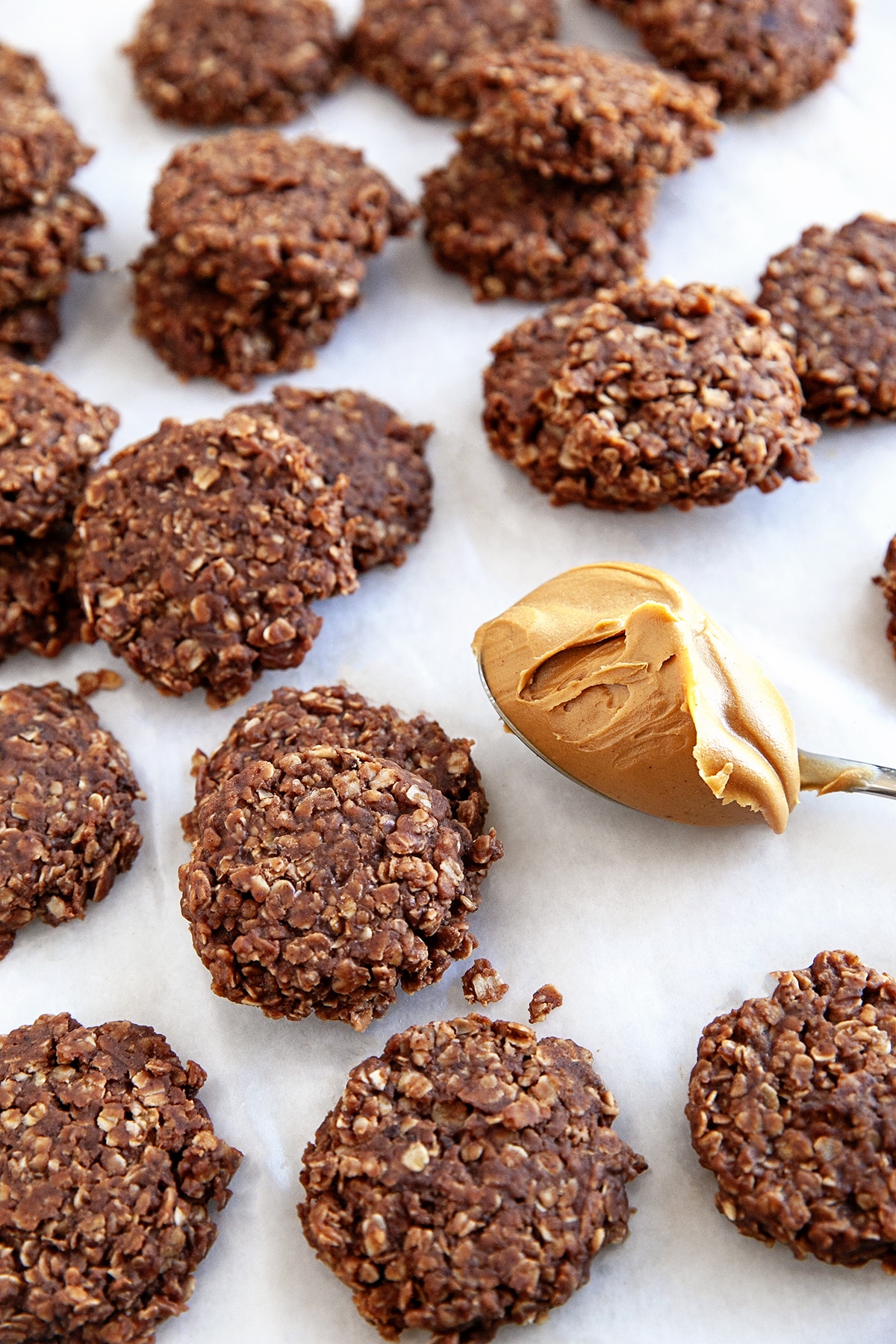 Cookies randomly on parchment with a spoonful of peanut butter. 