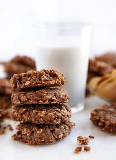Chocolate no-bake cookies stacked but a glass of milk.