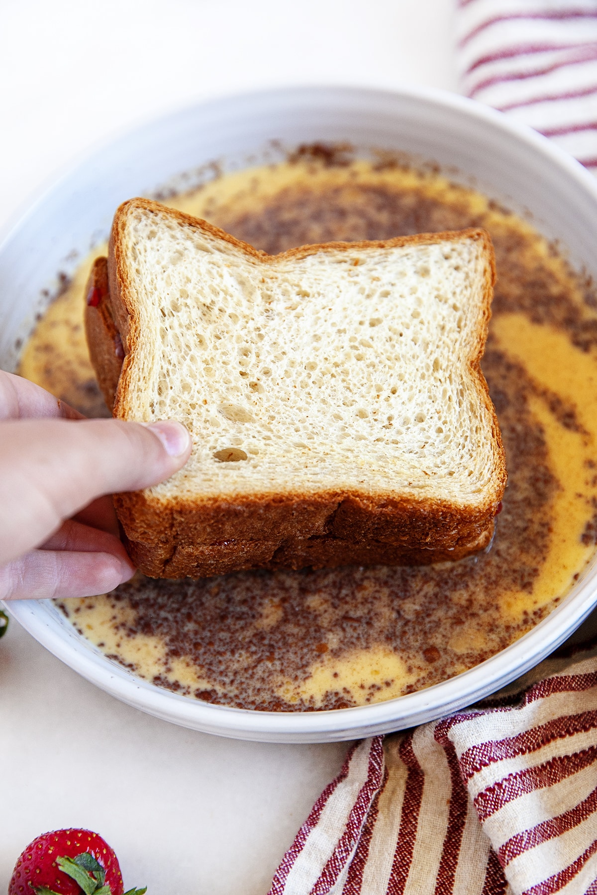 Dipping stuffed French toast in an egg mixture. 