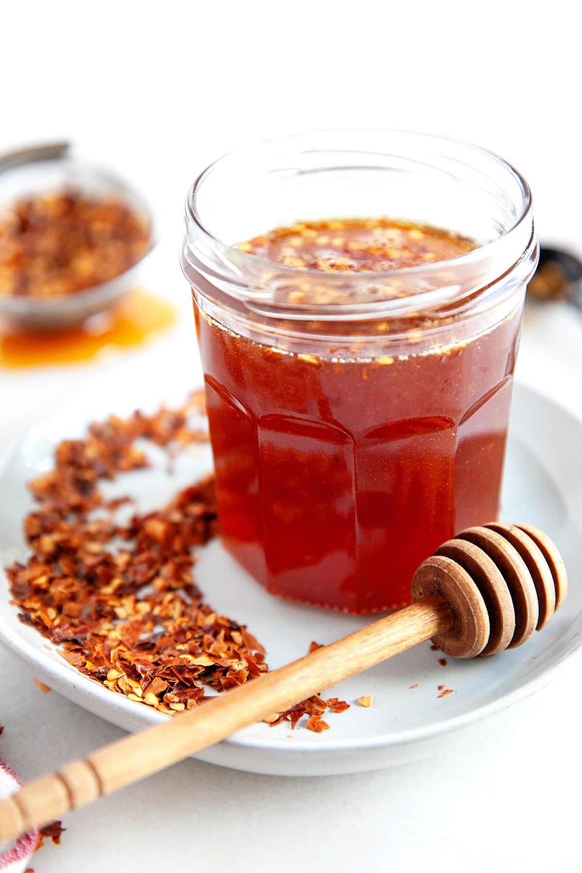 Front view of hot honey in a jar with a dipper. 