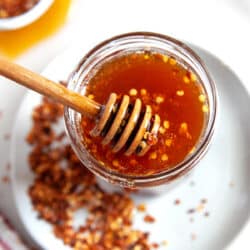 Overhead shot of hot honey in a jar with a dipper.