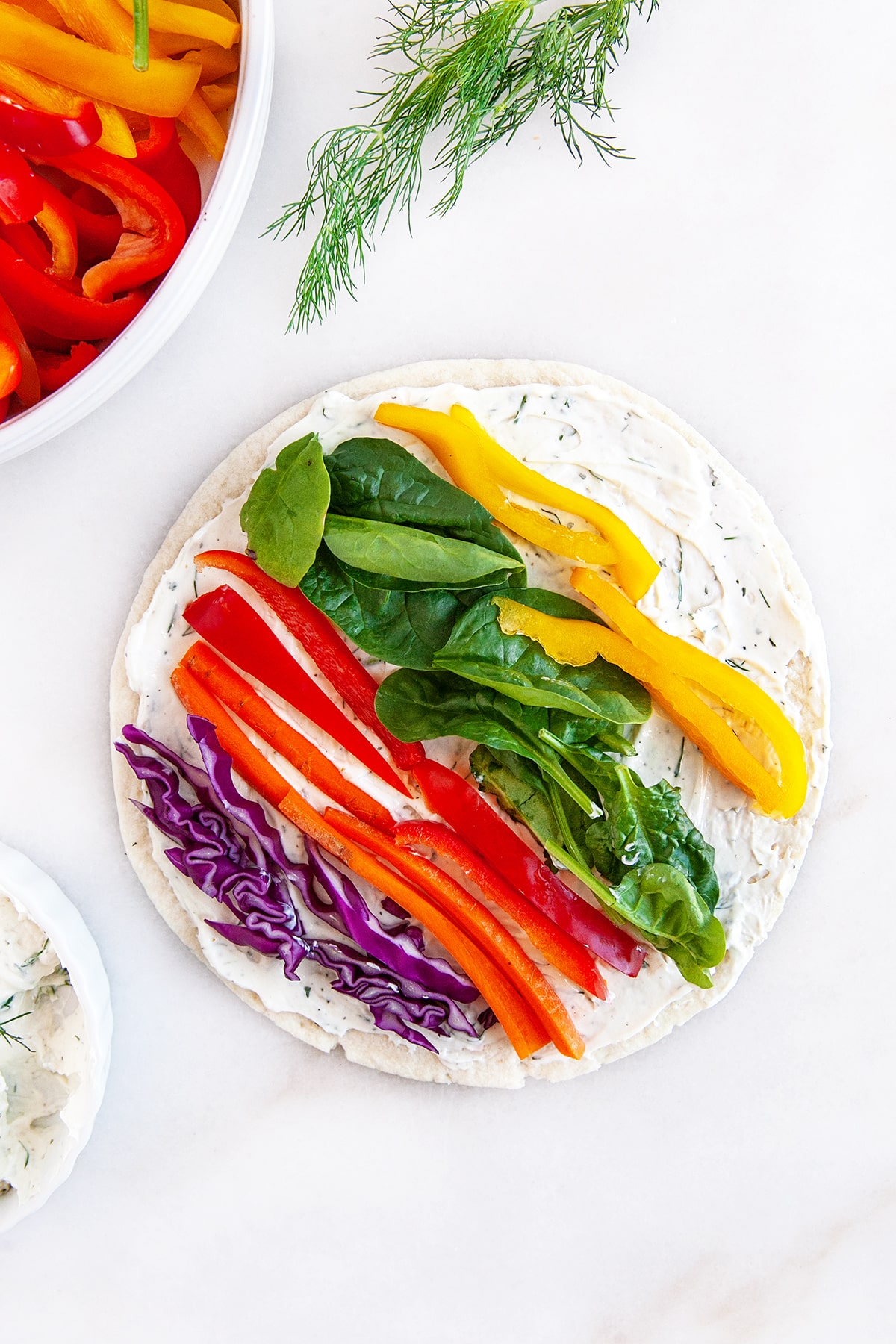 Overhead shot showing vegetables laid down in a cream cheese tortilla. 