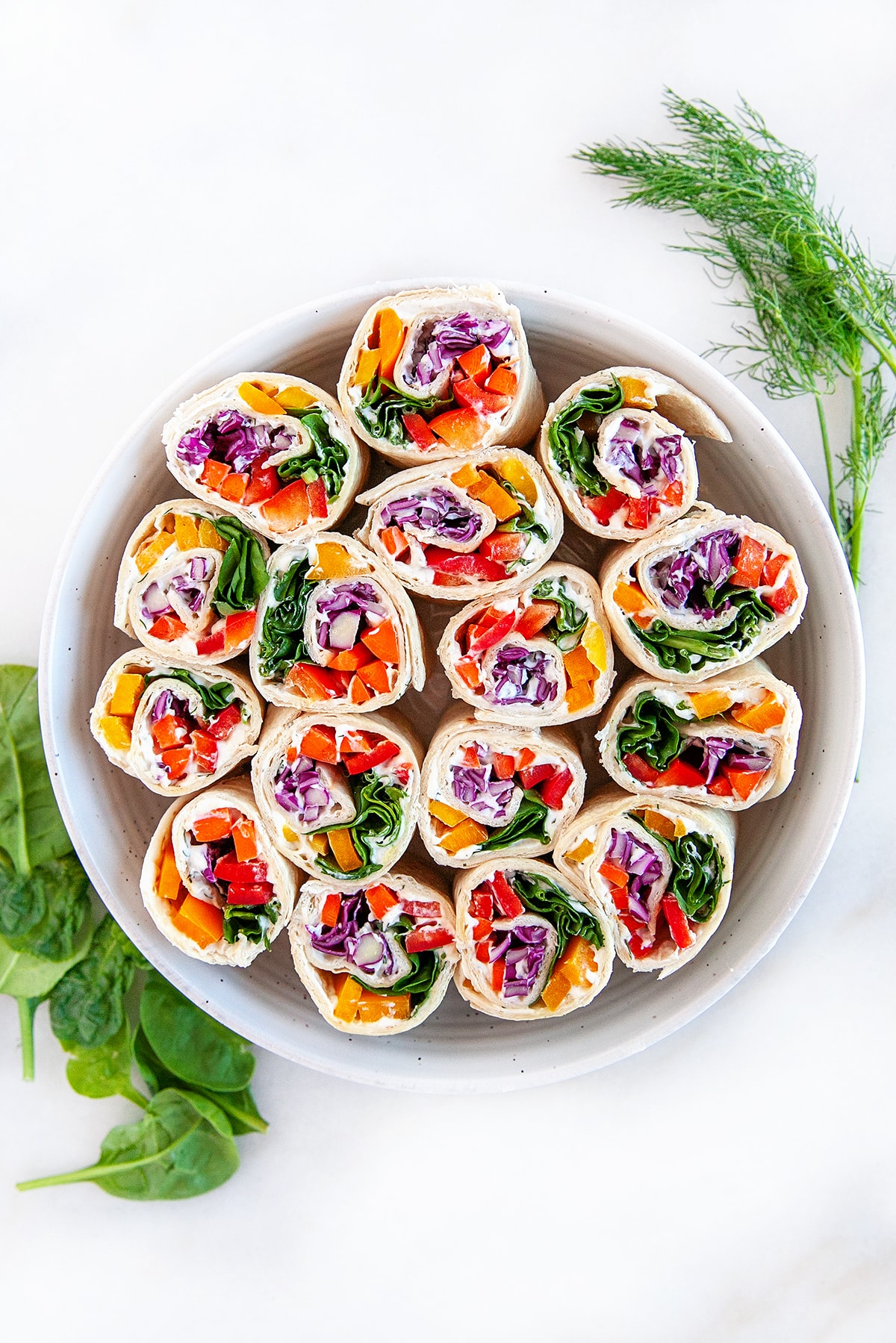 Overhead view of pinwheels in a round dish. 