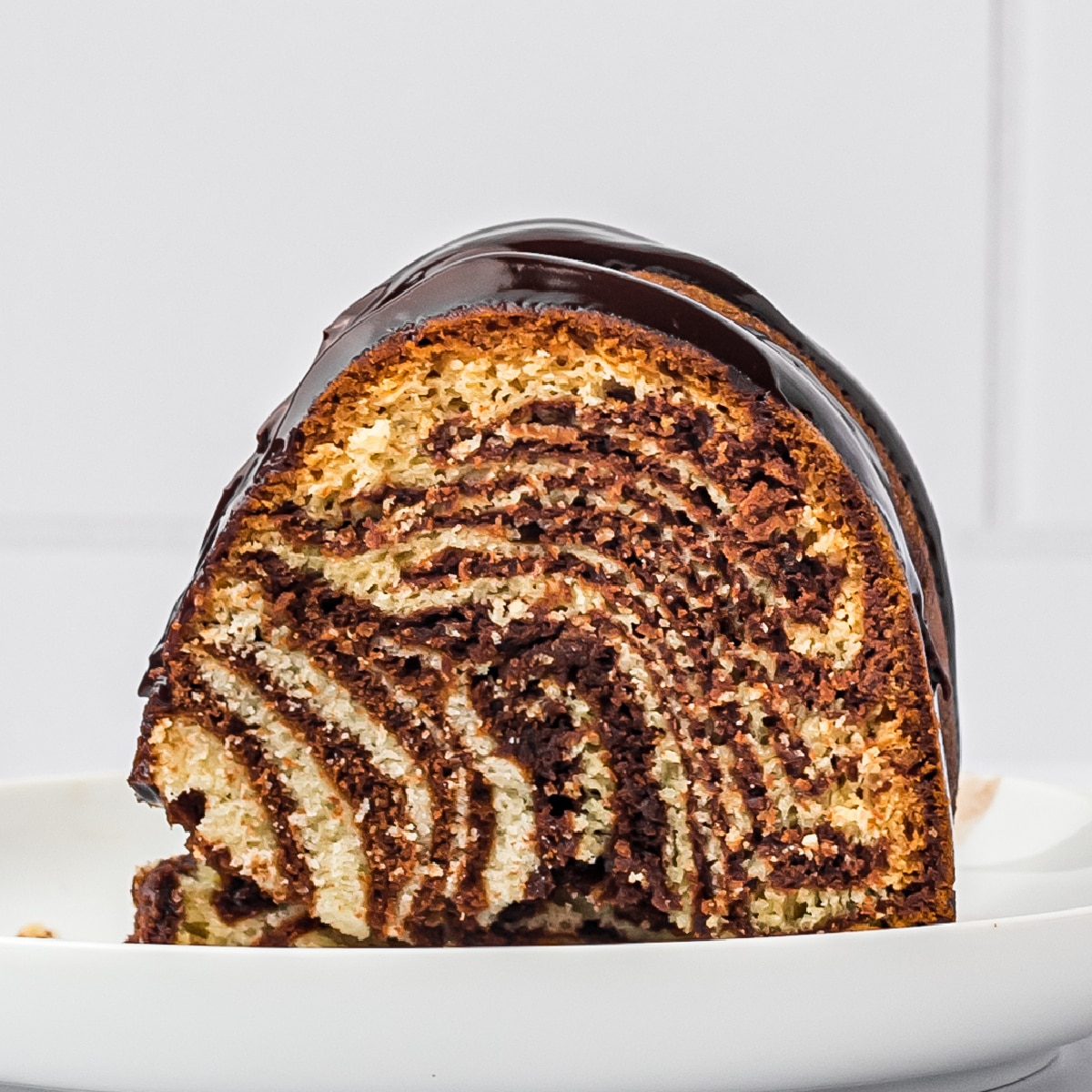 Square photo of a slice of zebra cake, front view. 