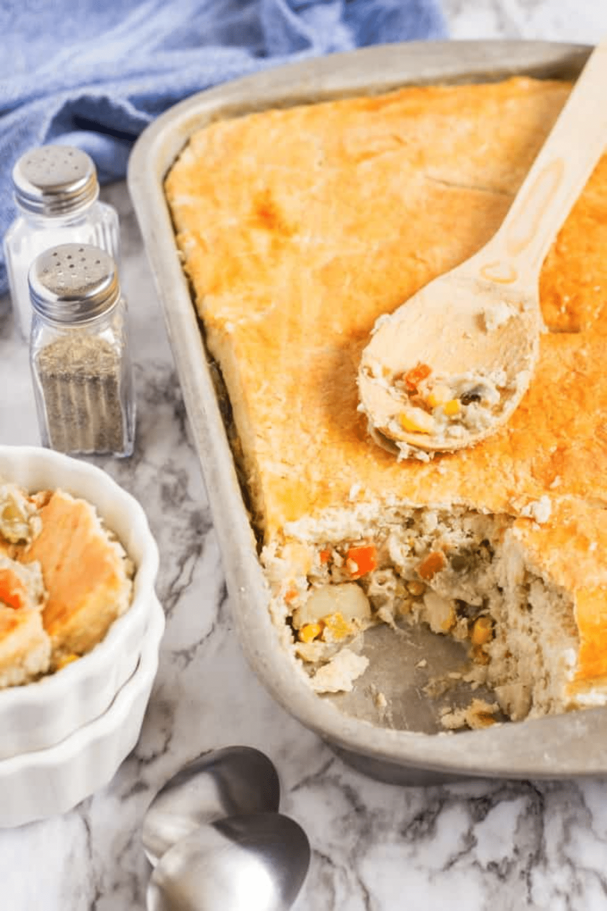 Chicken pot pie in a large pan with a scoop taken out. 
