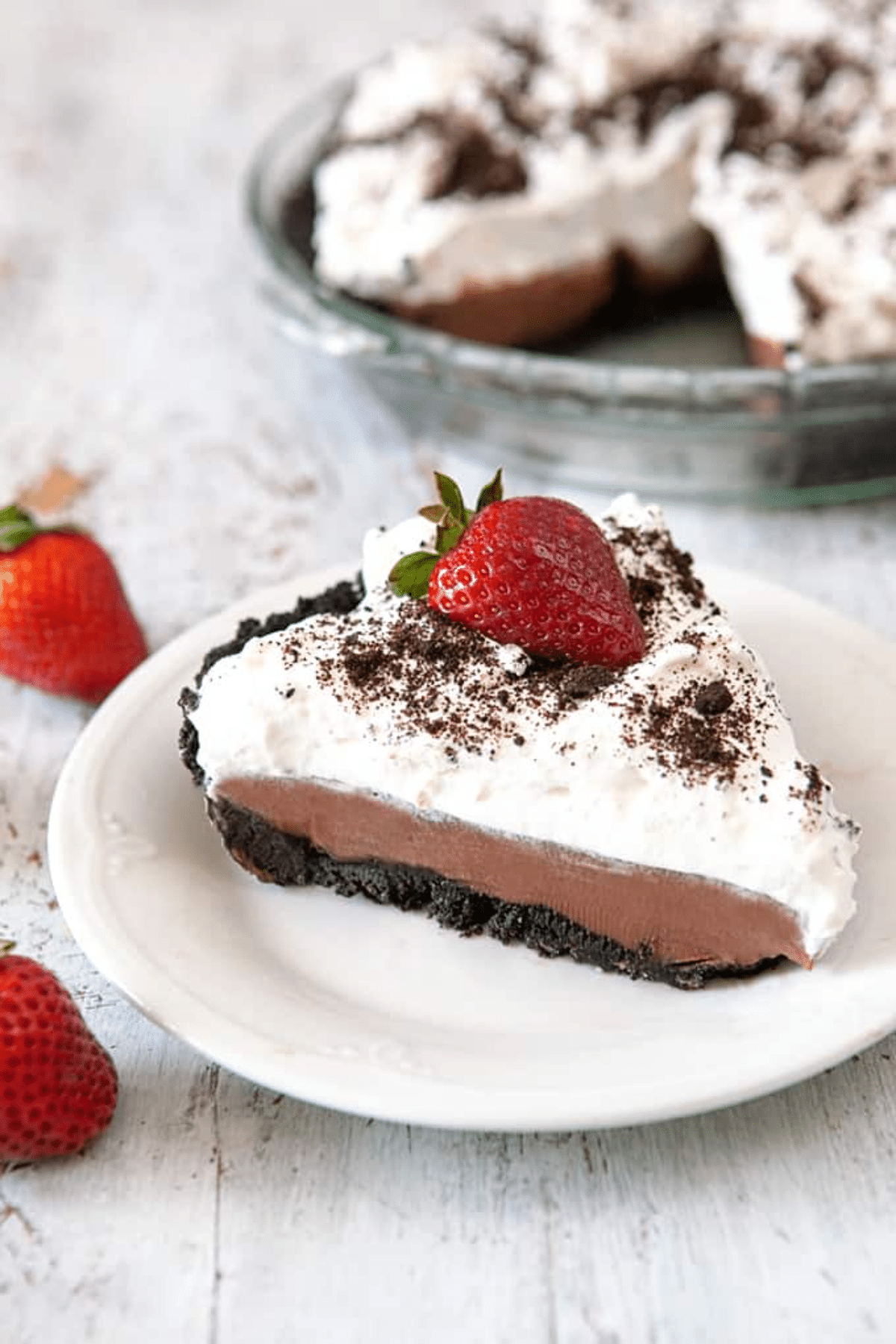 Chocolate Pudding Pie slice on a white plate with a strawberry on top. 
