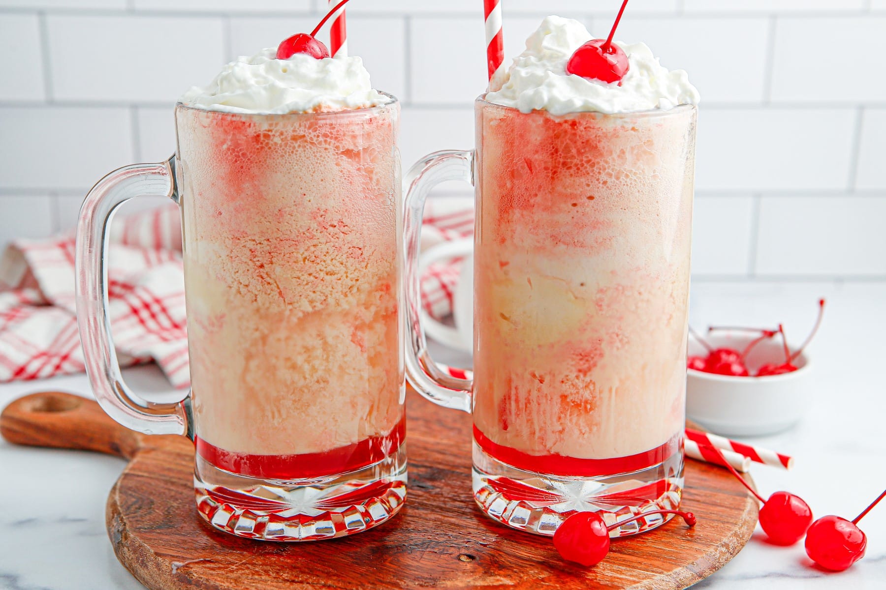 Horizontal picture of cherry floats on a board with cherries around. 