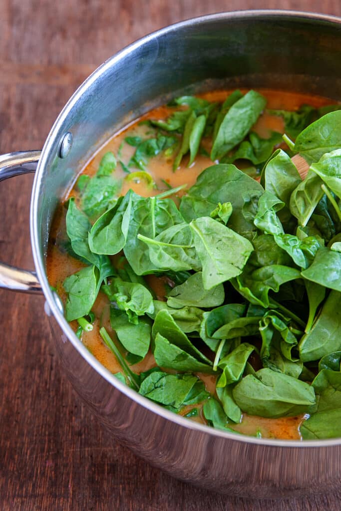 Adding spinach to the broth. 