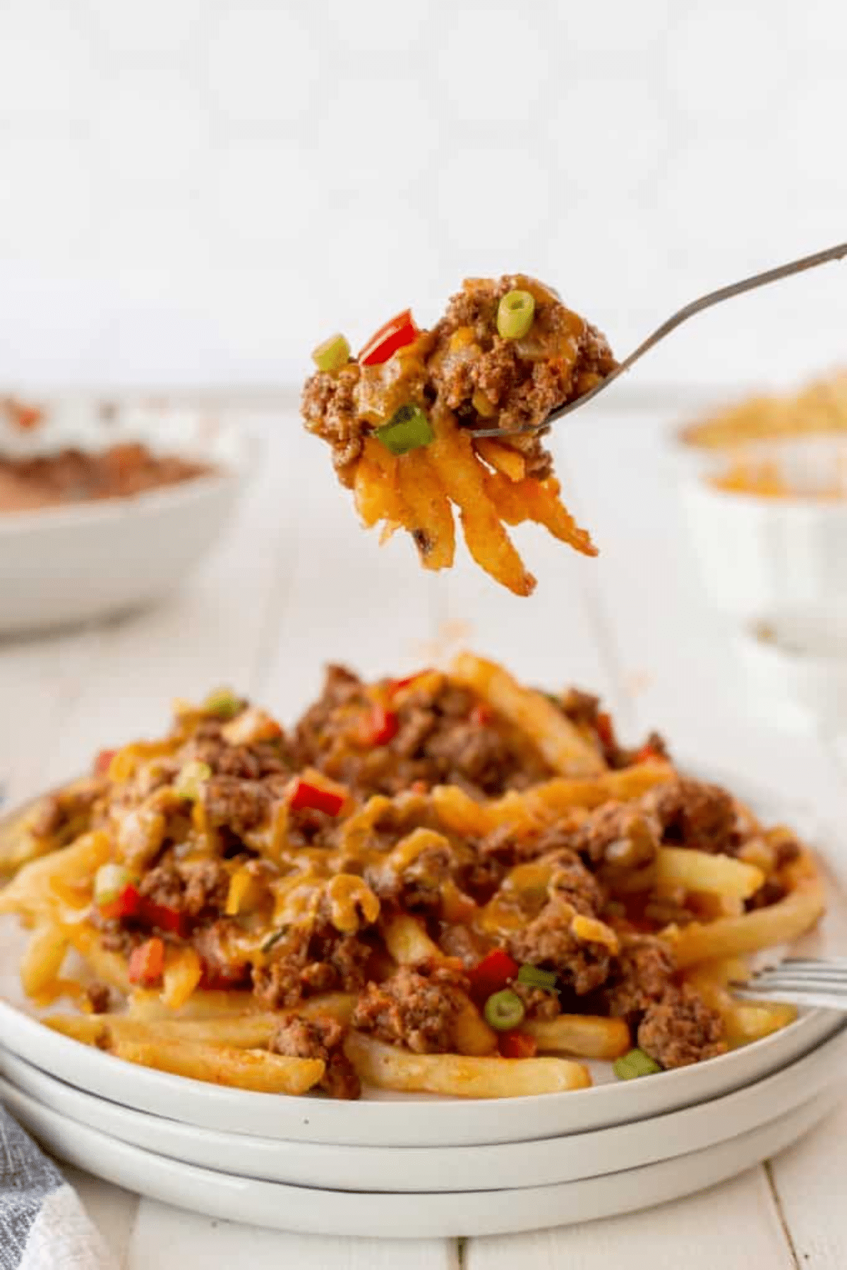 Taking a forkful of chili cheese fries. 