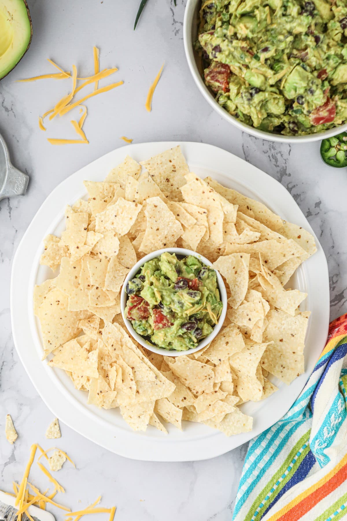 Overhead shot of a small round bowl of guacamole surrounded by chips. 