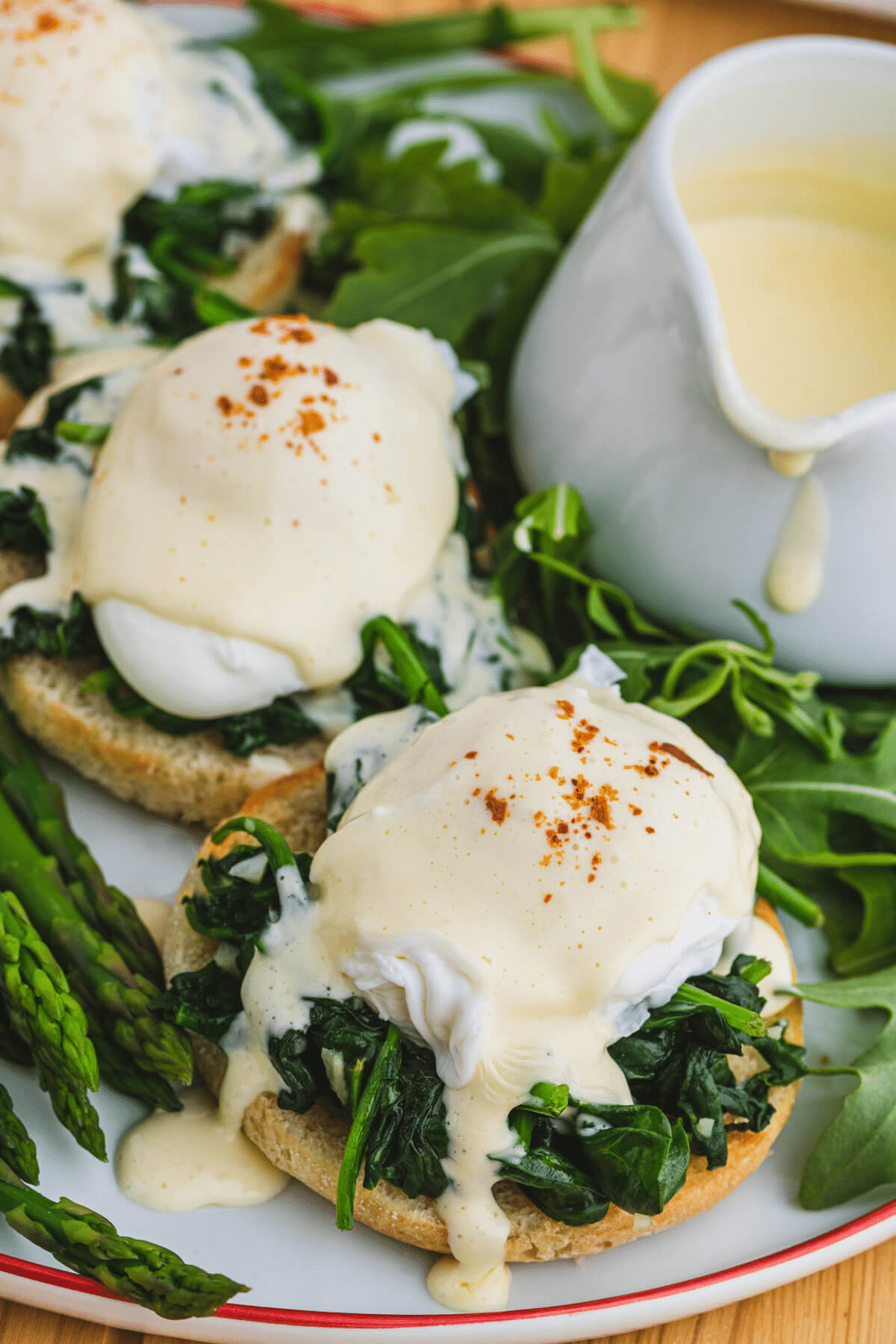 Eggs Benedict Florentine on a plate wth asparagus and extra Hollandaise. 