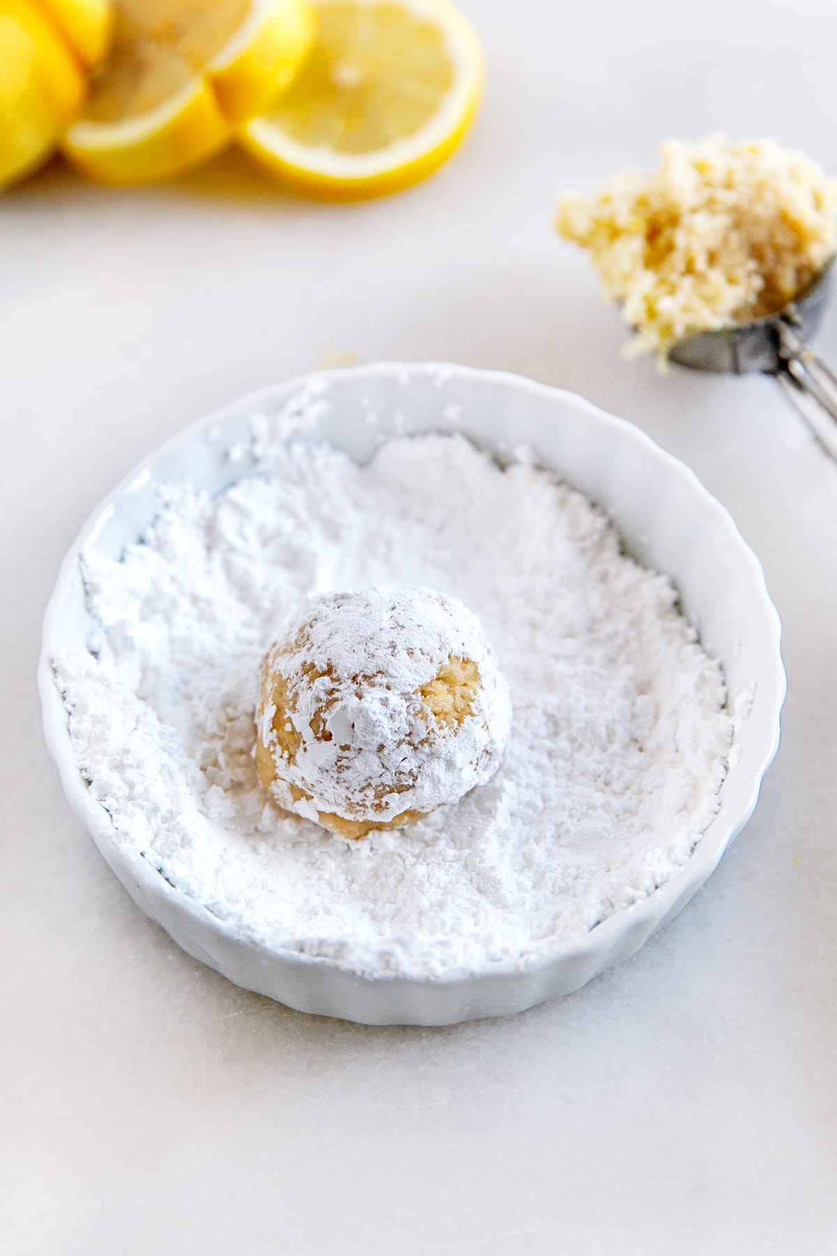 Rolling a dough ball in powdered sugar. 