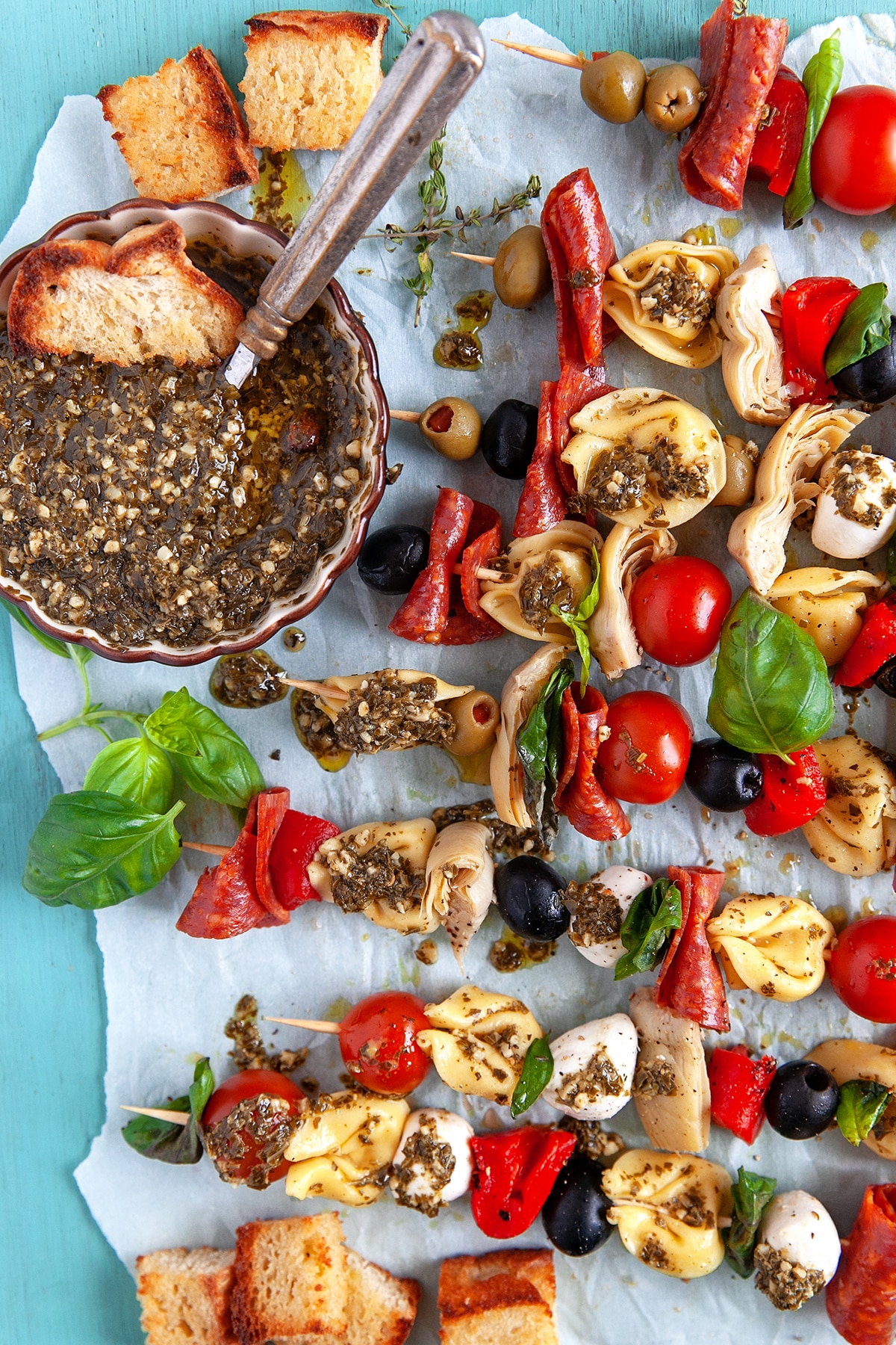 Overhead shot of tortellini skewers on parchment paper. 