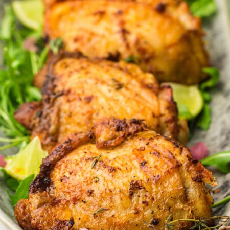 Platter of air fryer chicken thighs on a grey platter.