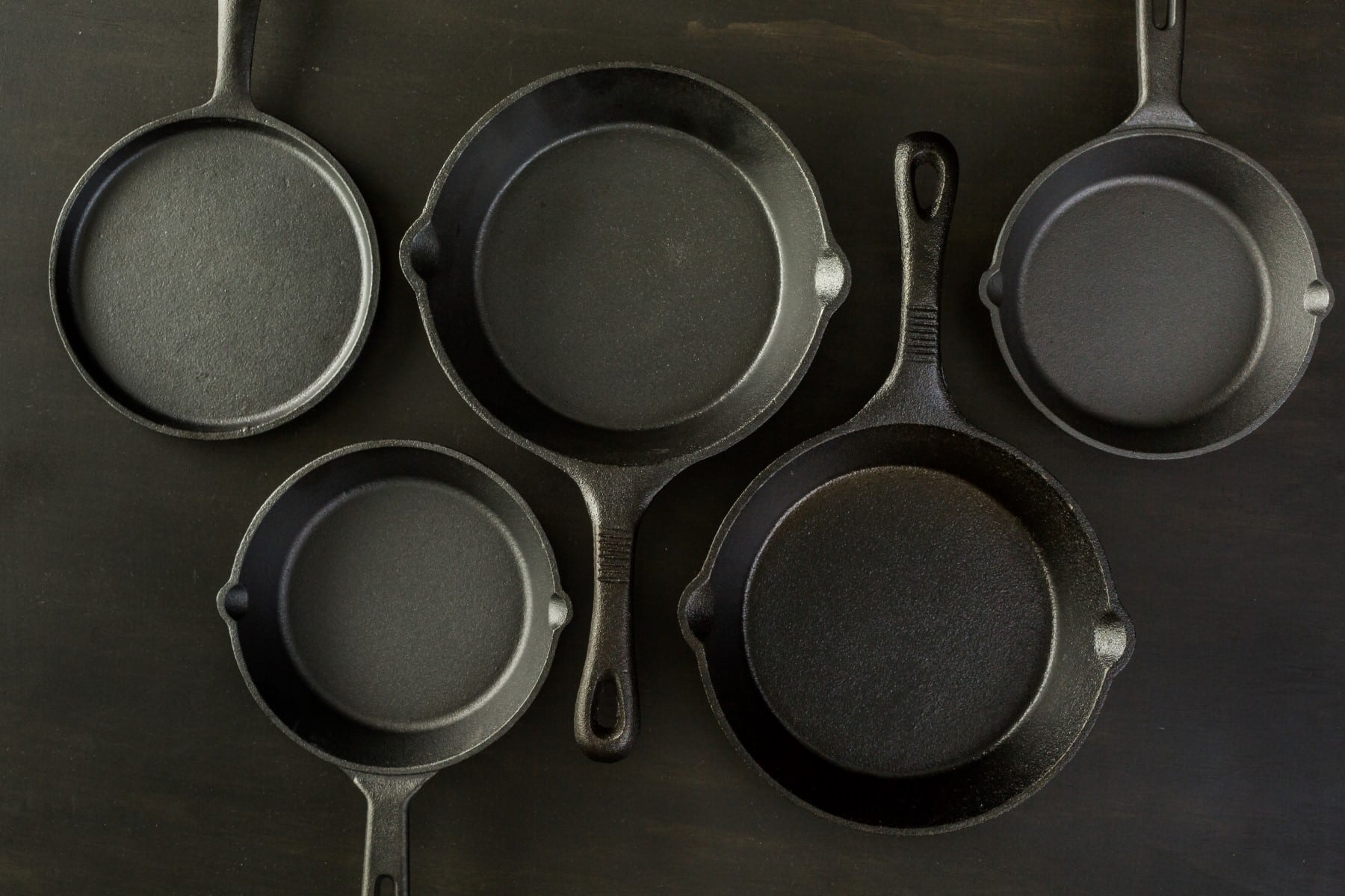 Traditional cast iron skillet on black wood table.