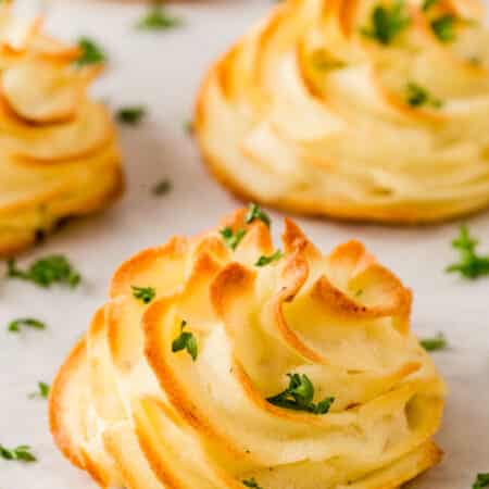 Close-up of Duchess potatoes on a baking sheet lined with parchment.