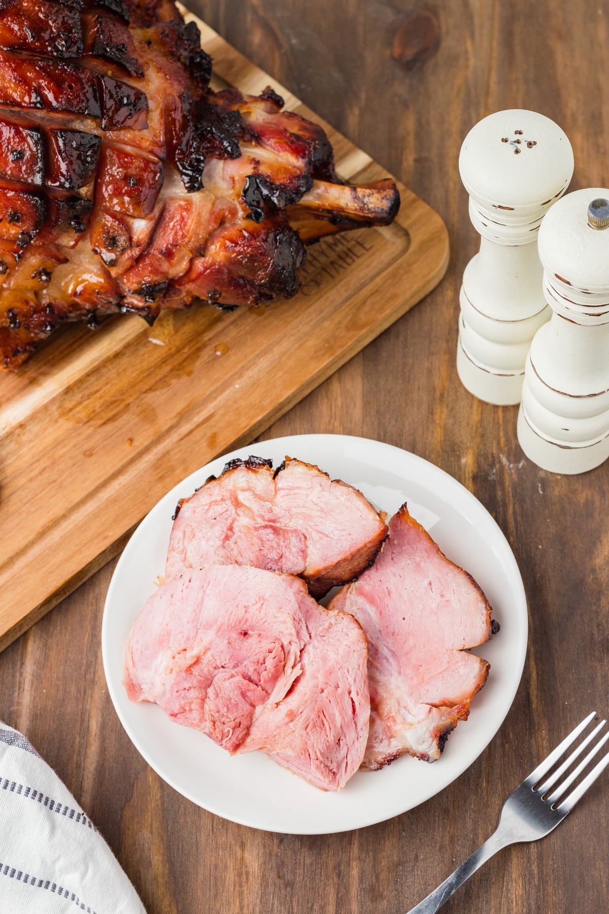 Sliced ham on a plate taken overhead with the ham on a board. 