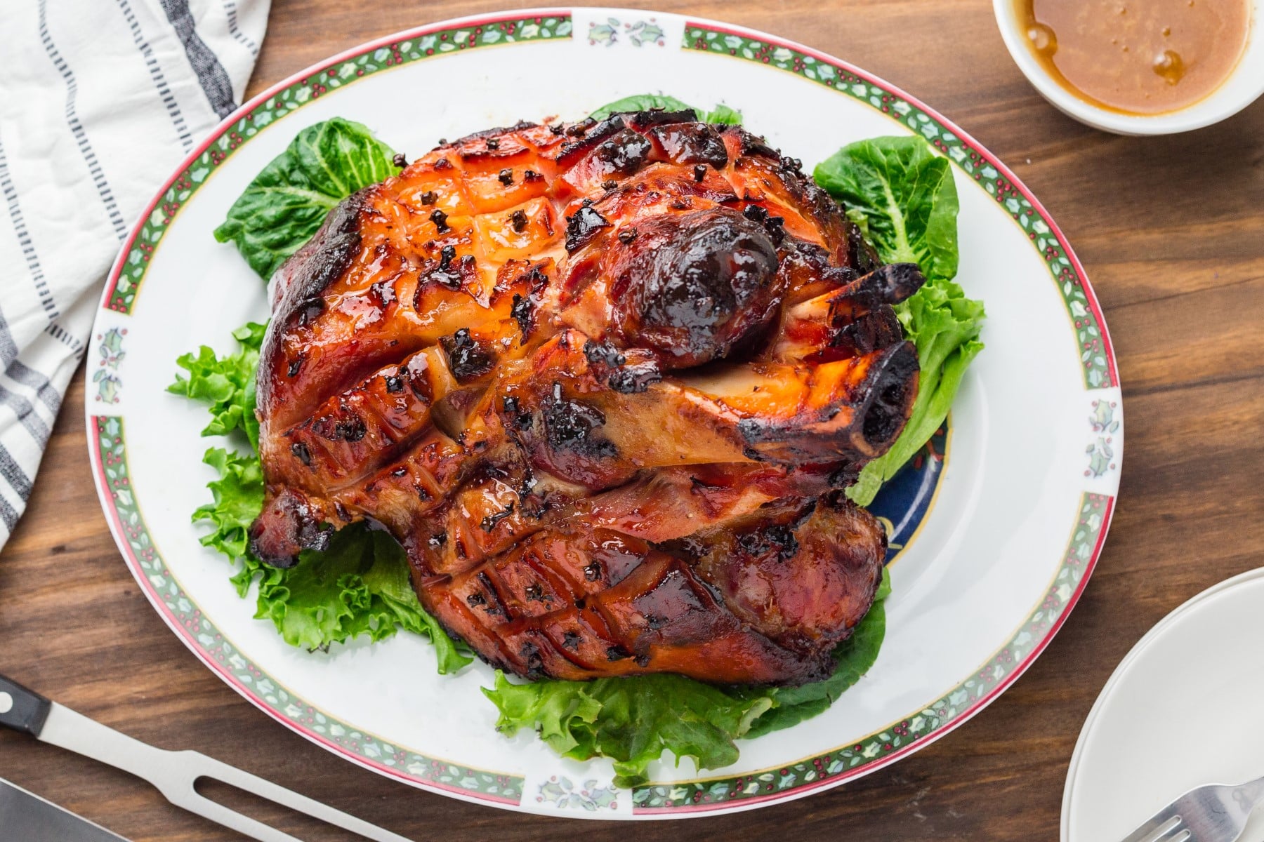 Horizontal shot of ham on a plate over lettuce. 