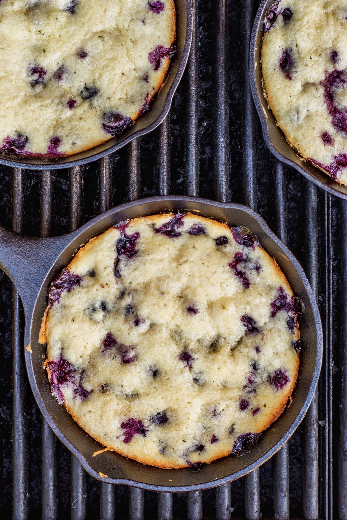 BBQ Lemon Blueberry Buttermilk Cakes in small cast iron pan on a grill, taken from above. 