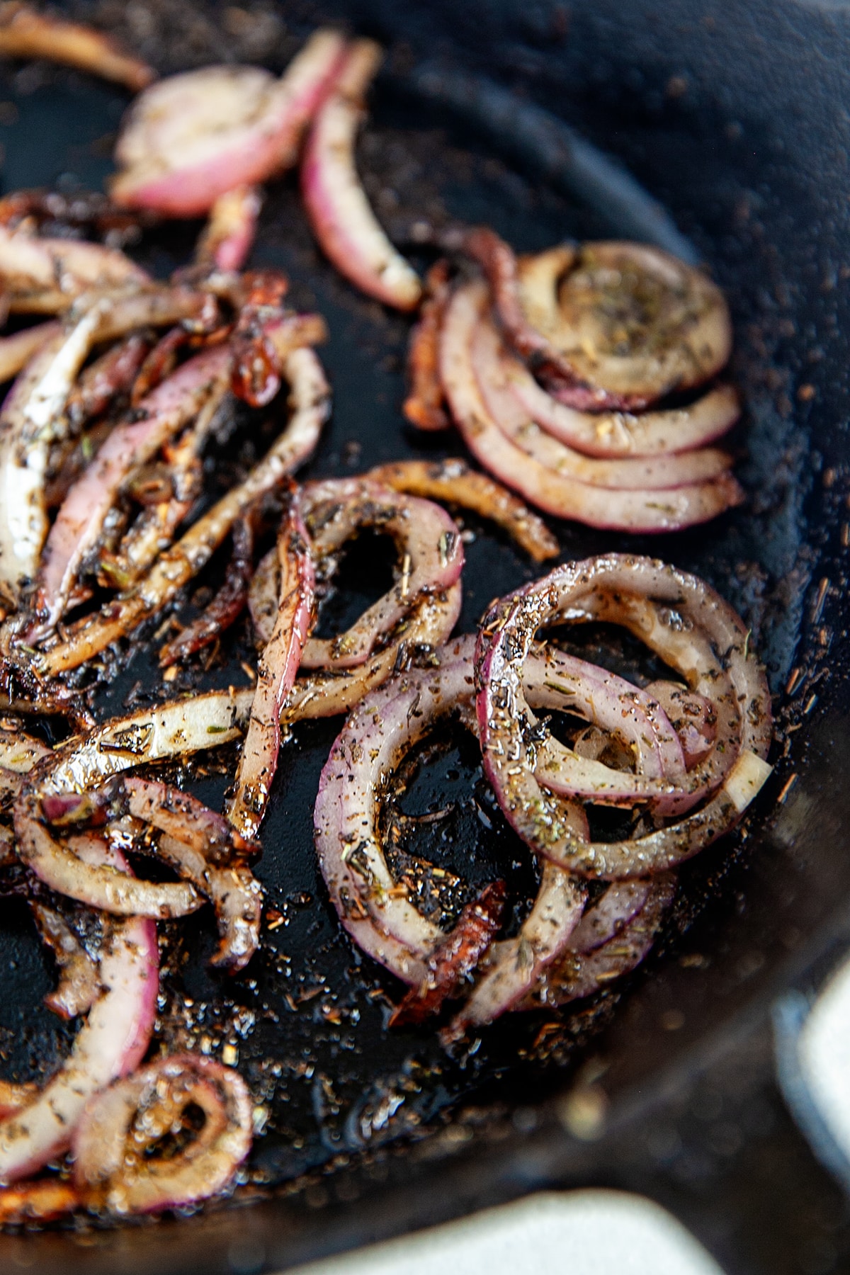 Red onions and herbs sauteed in a cast iron pan. 