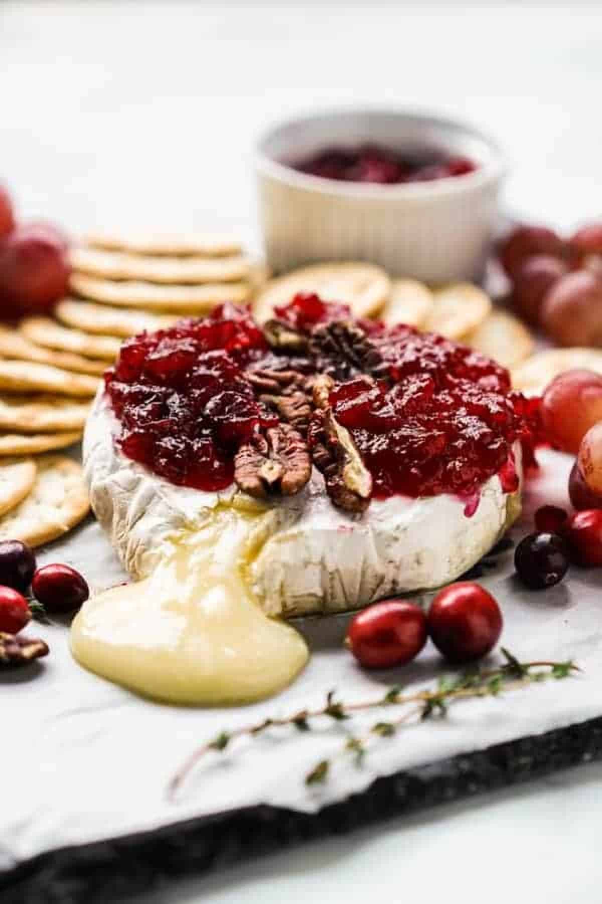 Side photo of Cranberry Baked Brie served with crackers. 