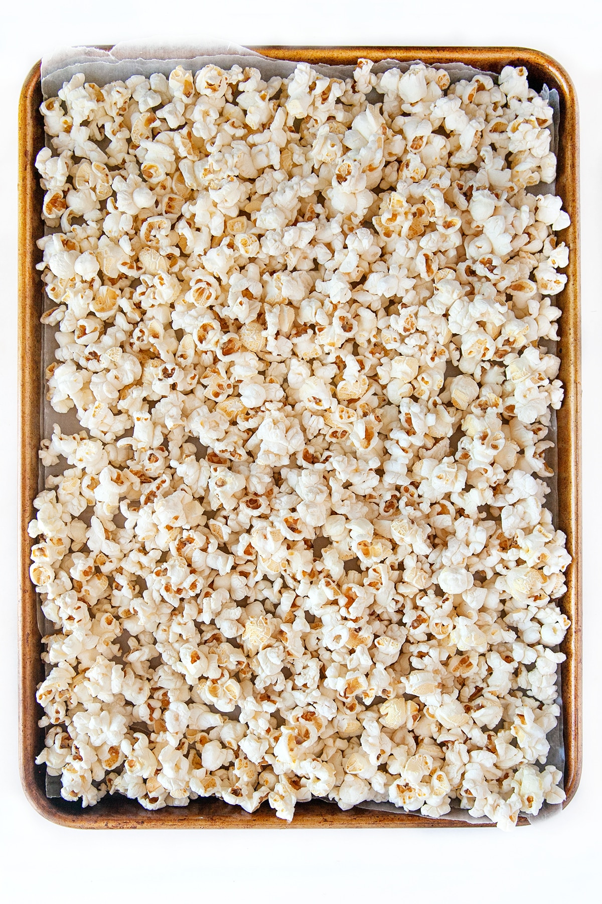 Baking sheet filled with plain popcorn. 