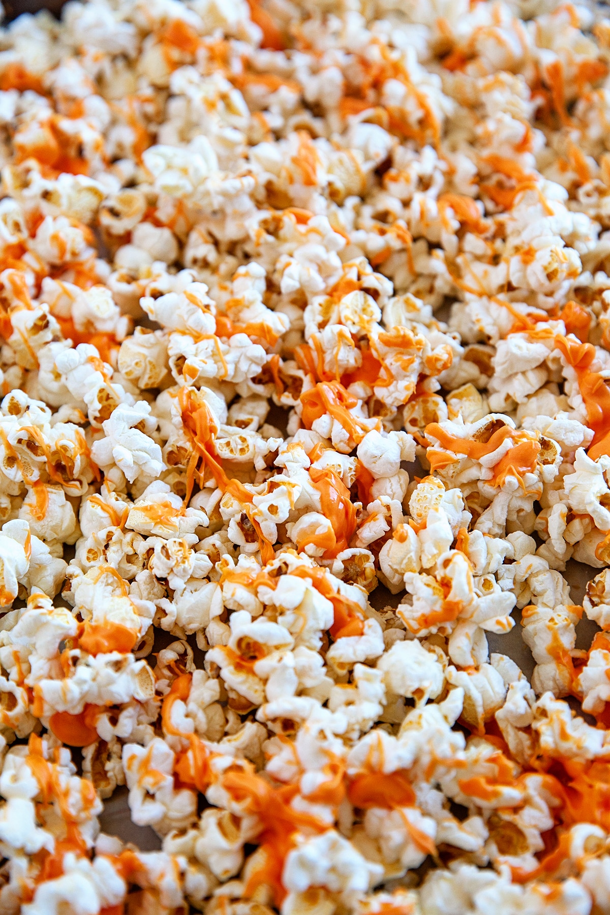 Popcorn drizzled with orange colored chocolate. 