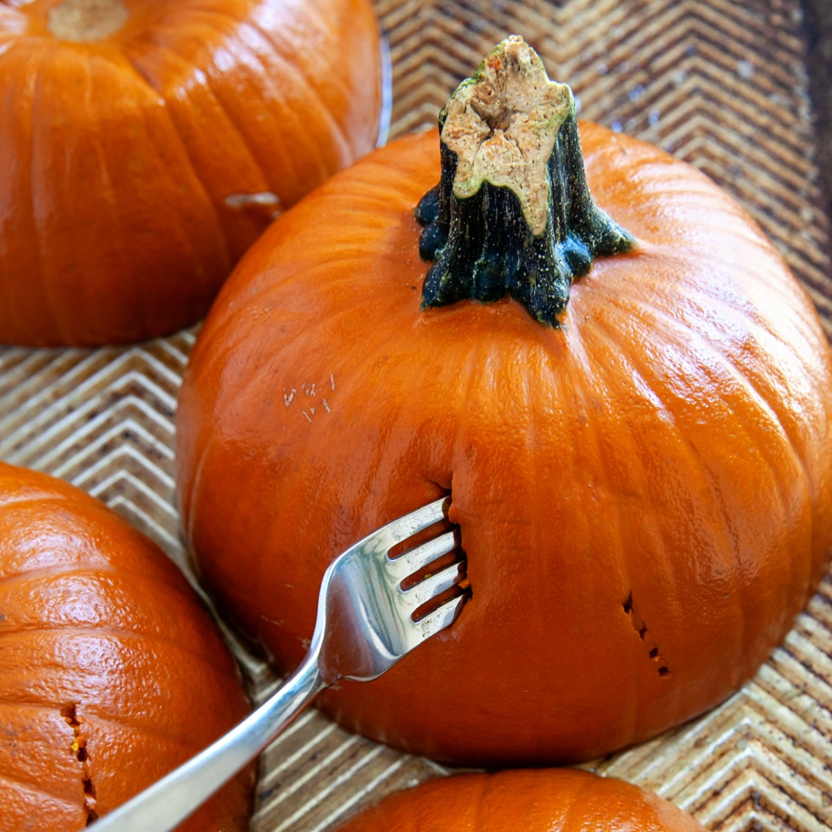 Poking a fork into a cooked pumpkin. 