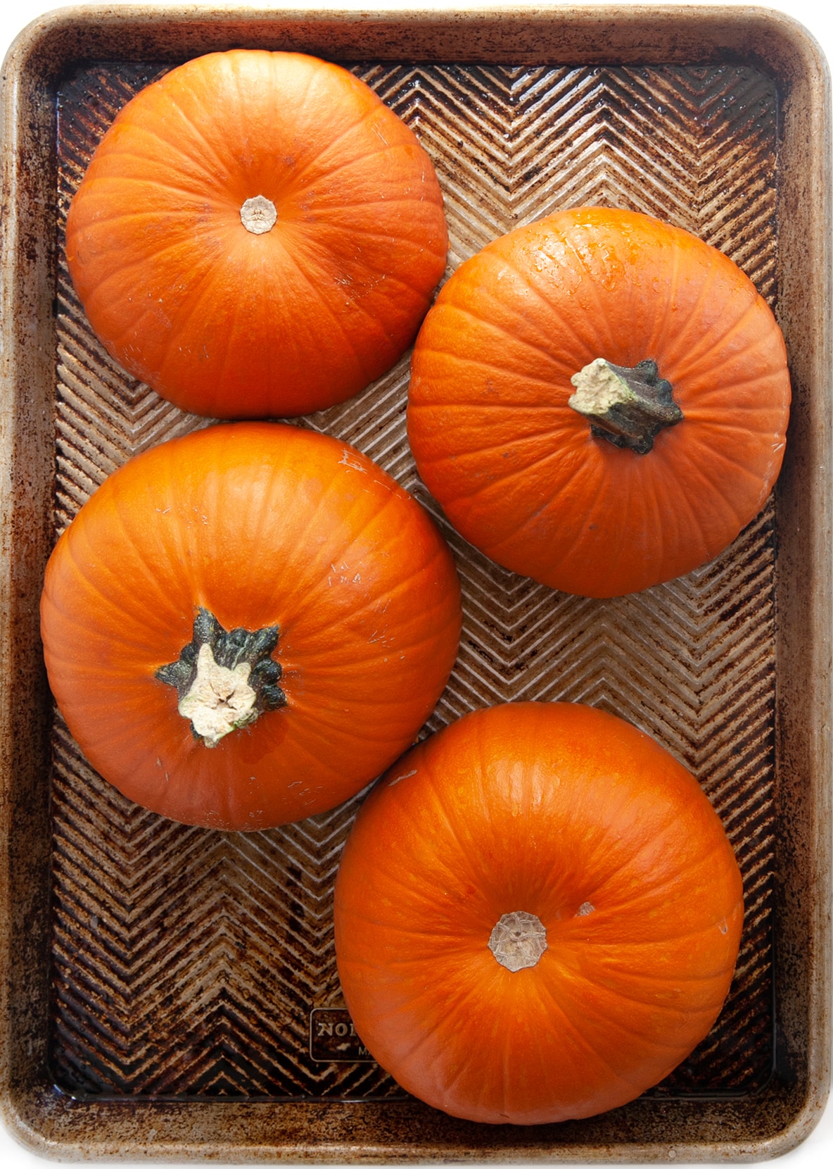 Halved pumpkins on a baking sheet showing How to Cook Pumpkin. 