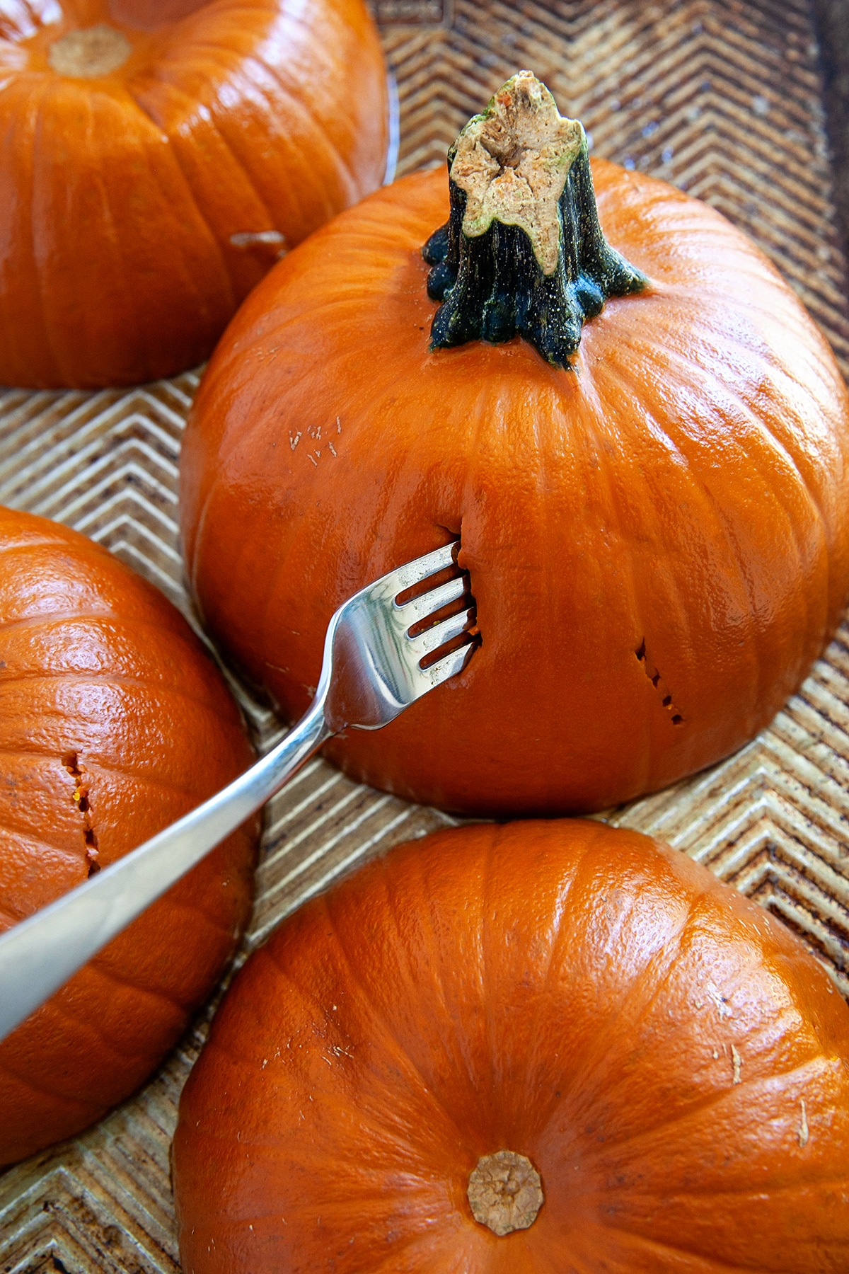 Putting a fork into a cooked pumpkin. 