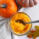 Fresh pumpkins and pumpkin puree in a jar, shot from overhead.