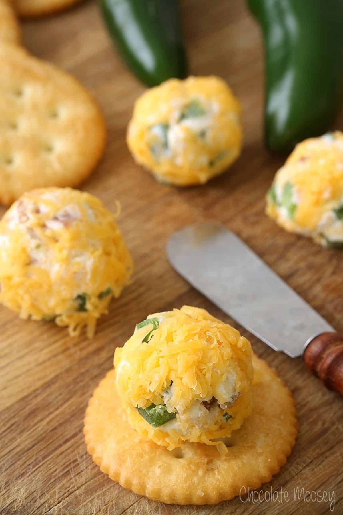 Side image of Jalepeno Popper Cheese Ball Bites served on a cracker.