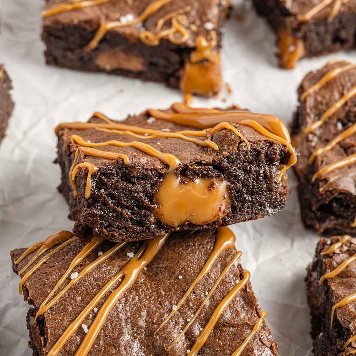 Square photo of salted caramel brownies showing the inside of a brownie with oozing caramel. 