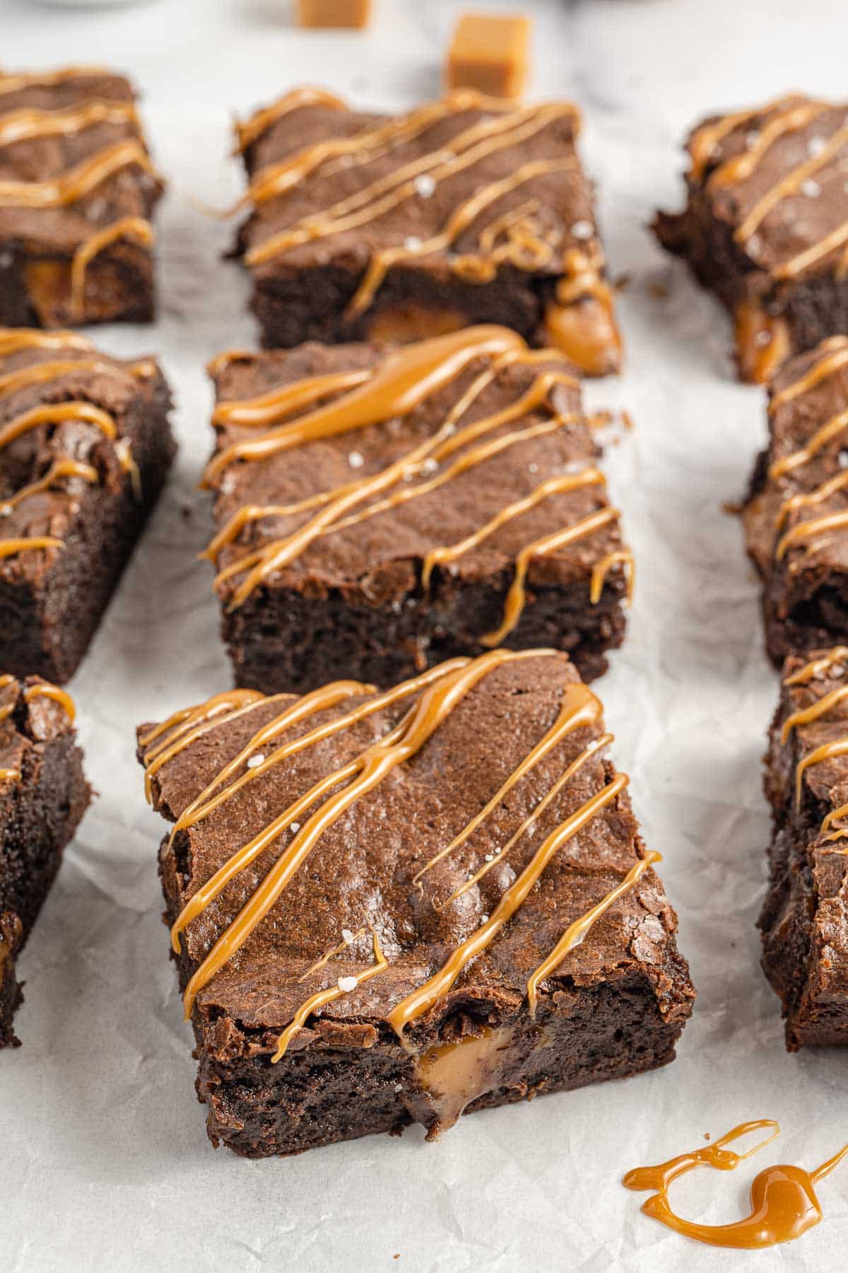 Brownies cut into squares drizzled with caramel. 